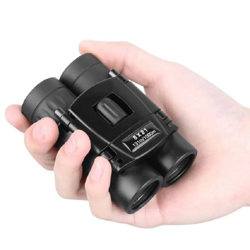 Black folding pocket binoculars held in one hand