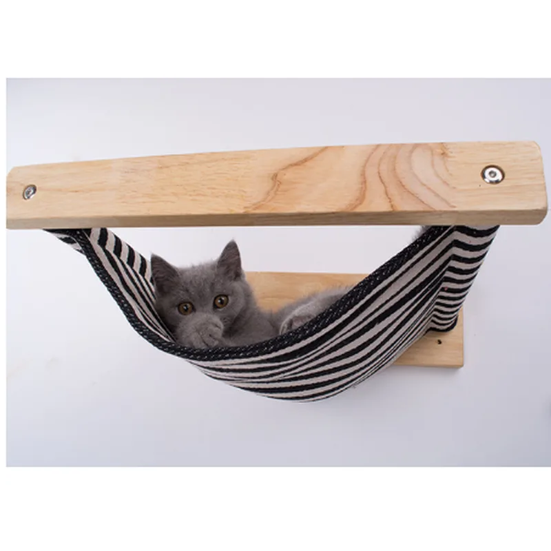 Grey cat lying in a wall-mounted hammock with a black and white striped sling