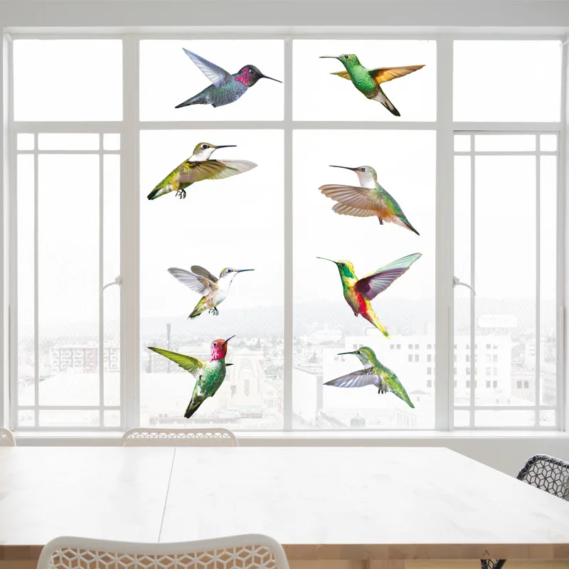 Nine hummingbird decals spread across the panes of a large window